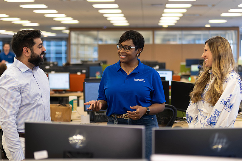 Three women smiling in an office setting